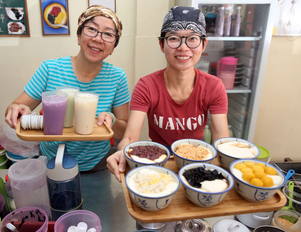 靓妈豆花店的冼丽娟（左起）和媳妇陈佩茹展示豆花店的镇山之宝。