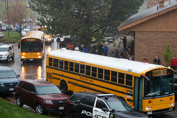 校車抵達學校，准備把疏散的學生接走。（美聯社）