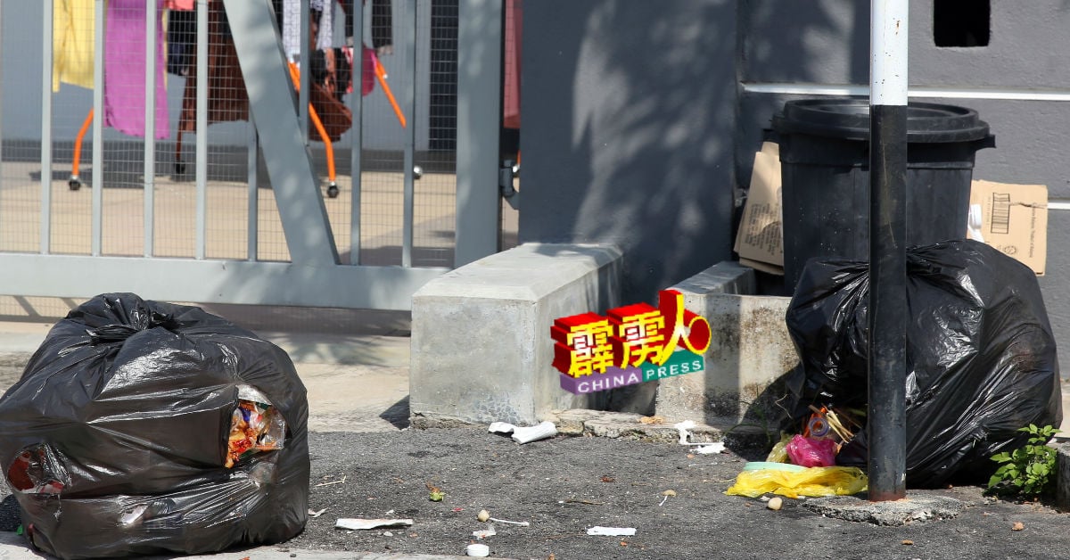 女外劳将垃圾置放在屋外，遭野狗拖咬，造成街道满地垃圾。