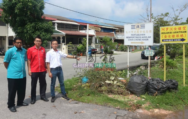 周敬程（右）指禁止丢垃圾告示牌遭拆除，路口旁空地再次堆积垃圾，左起杰夫里及陈明岳。