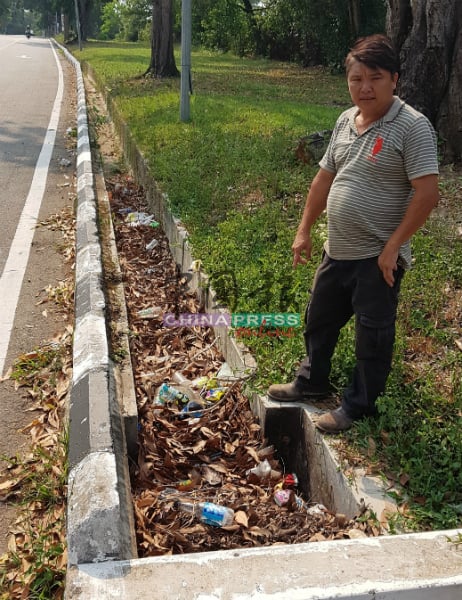 余建南对沟渠积满树叶感无奈，并担心会影响排水系统。