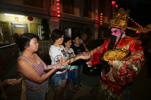 财神爷派发元宝给民众。