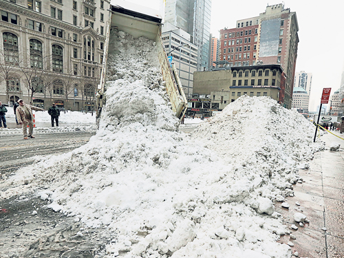 在紐約市世界貿易中心附近，一輛卡車把收集到的雪倒在空地上，讓它在該地融化。（美聯社）