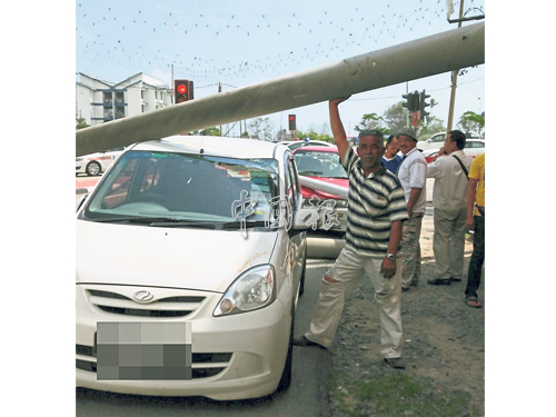 柱子壓著一輛薇華轎車，導致車頂損壞。