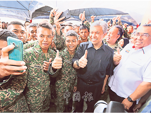 阿末扎希（右）宣佈凍結引進外勞后，與一眾軍人豎起拇指自拍，氣氛融洽。