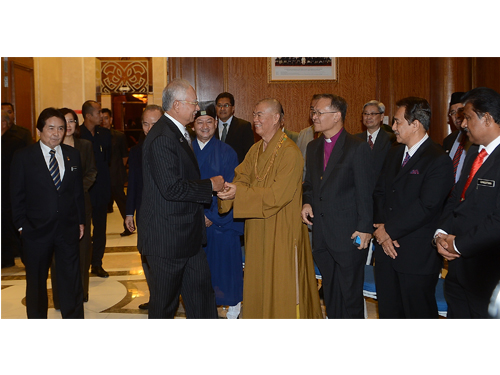 纳吉（左二）与日恒法师握手，左为佐瑟古律。首相过后颁发委任状给跨宗教和谐及谅解委员会。
