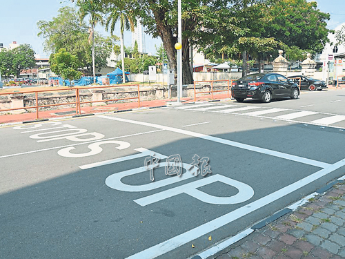 马路上写着大大的「STOP」（停），提醒车主在斑马线前停下，让行人过马路。