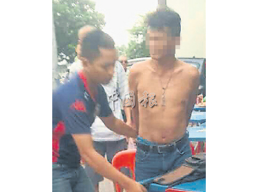 嫌犯（右）被公眾追捕后，由警員押往警局。 