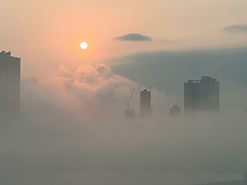 雾漫香港，维多利亚港雾海笼罩高楼大厦，形成一座“天空之城”。（新华社） 