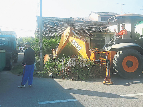 市政廳出動坭機清理空屋雜草。