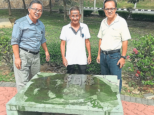 周世揚（左起）、鍾政光和葉運華視察公園內一張被人潑上黑油的石凳。