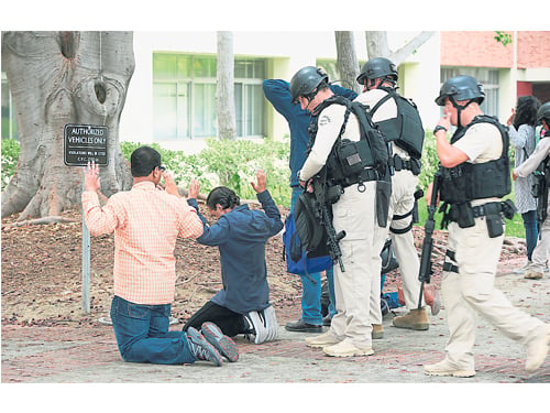 師生們被要求雙手舉在頭頂，排成一隊逐一接受警察檢查。（美聯社）