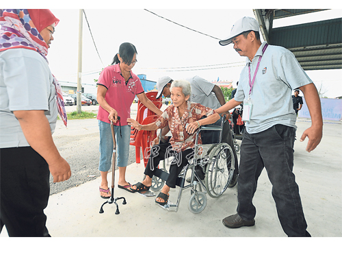 來自大港港口的82歲選民王賽娥，在家人陪同下前往投票。