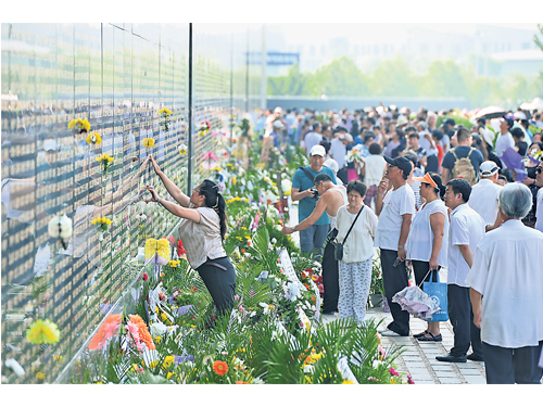 週四（28日）是中國唐山大地震40週年。唐山地震紀念牆在當天迎來大批當地民眾。民眾在牆前獻花，紀念當年的遇難者。唐山地震紀念牆是紀念于1976年7月28日3時42分發生的唐山大地震中死亡的24.2萬人。牆上刻有遇難者的生辰、出資者的姓名及與死者的關係。（新華社）