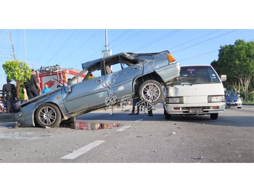 轎車未知何故失控，撞擊安全島上的大花盆，轎車后半身複“跳躍”至客貨車上。