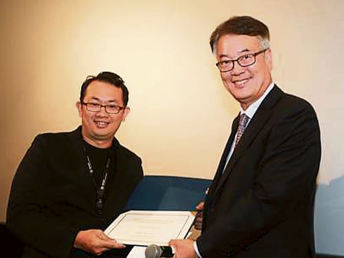 来自马来西亚的程添建（左）从东西大学副总裁JO Jeung Seong手里领取 Dongseo University Scholarship Fund。