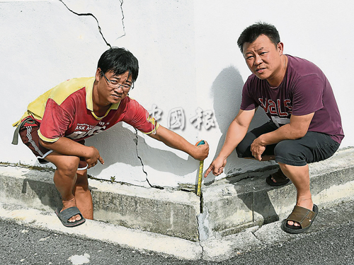 居民許友欽（左）及姚健勇本月32日帶領媒體，視察出現裂縫的單位。（檔案照）