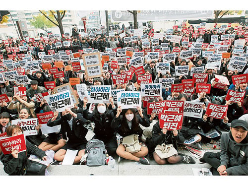 韩国高校学生周六在首尔聚集，高举标语促朴槿惠下台。（美联社）