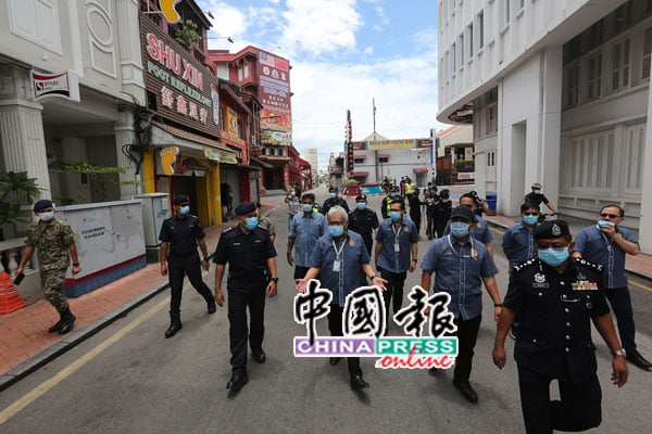 官员在大批警官陪同下，走在无人的鸡场街表示满意。