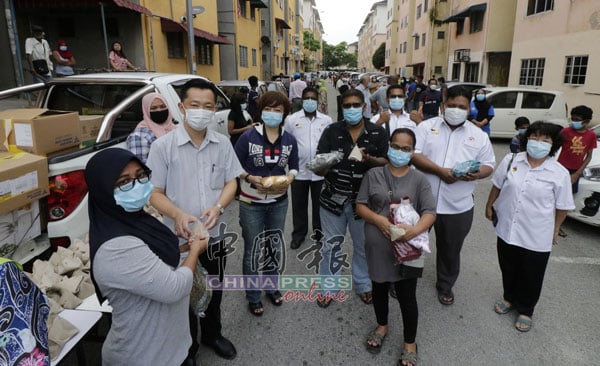 武吉甲巴央区服务中心连同非政府组织派发物资给芙蓉新城多区的组屋居民，左2起为谢琪清、陈丽群、安努华及姆鲁甘申（右2）。