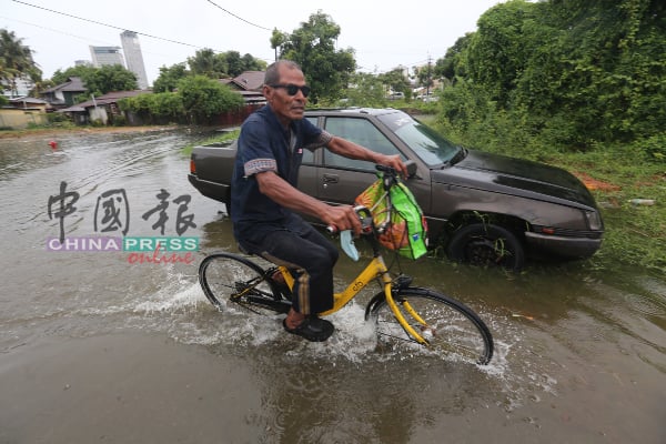 当地居民在水深近一尺的道路骑脚车出入三芭弄。