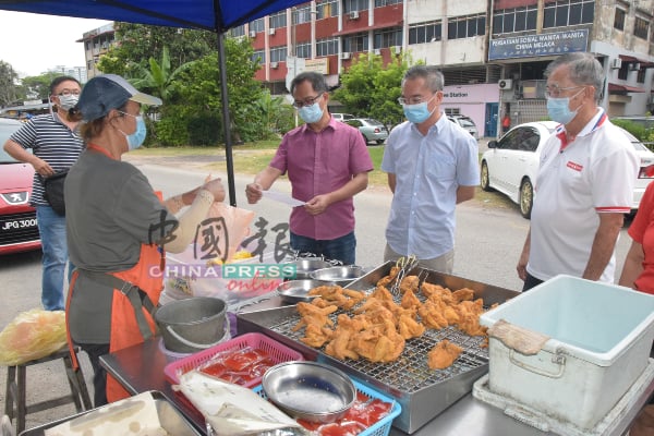 陈劲源（右起）、邱培栋及刘志良正研究市政厅执法官员所发出的通告内容。