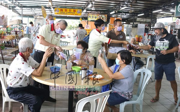 叶耀荣（站左）与团队们一起派发口罩给民众，提醒民众记得戴口罩，也切勿乱丢用后的口罩。