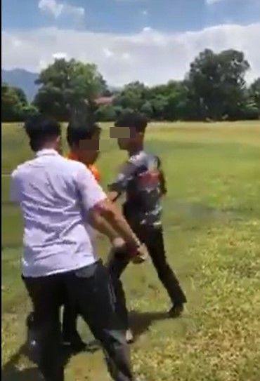 一名身穿橘色T恤的学生，遭2名同学殴打霸凌。