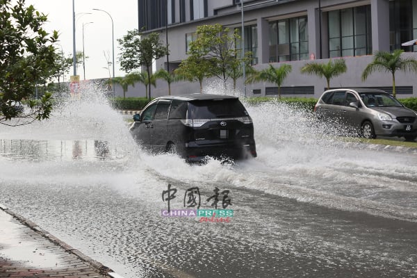 一些车辆在淹水道路上涉水而过。