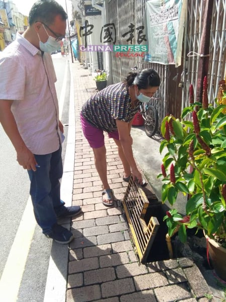 刘志良（左）到鸡场街勘察排水沟是否堵塞积水。