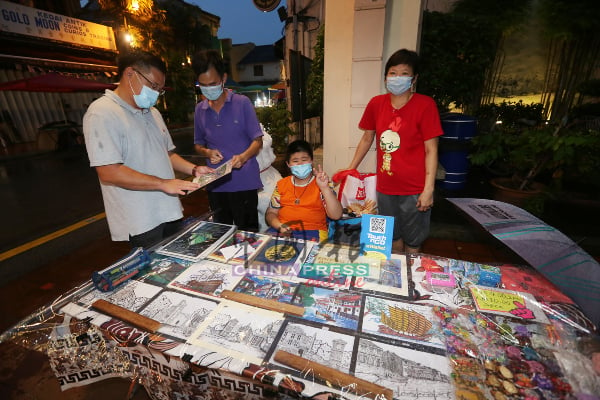 颜天禄（左起）参观聋哑画家刘汉荣的作品，后者开始在世遗公园摆摊。