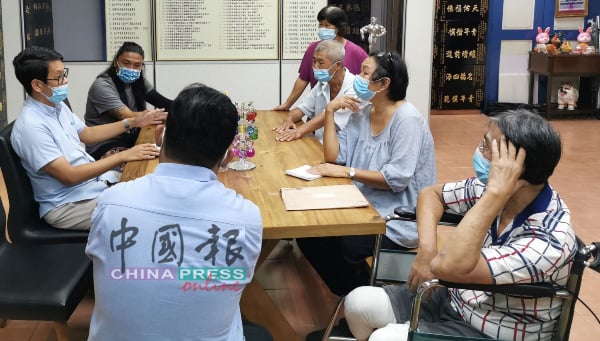 陈炜建（左）向鸡场街世遗公园残疾人士及街头艺人设摊专区申请者们解说营业细则。