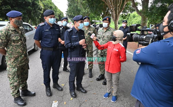 阿都马吉（前排左3）在路障地点，接受媒体访问。