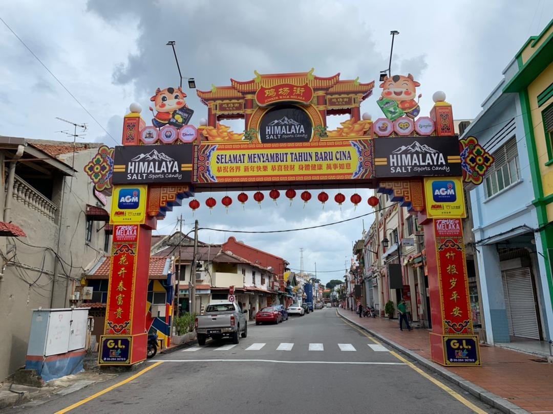 鸡场街舞台旁的年景牌楼以“花开春富贵，竹报岁平安”对联，迎接春节的到来。