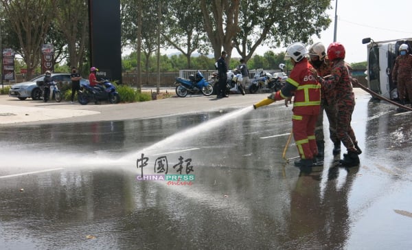 消拯员赶抵现场，清洗路面油迹，避免危及其他公路使用者。