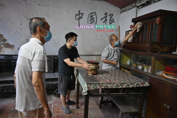 ■沈墨义（右起）、沈林炳及沈墨浮在祖先龛前大扫除。