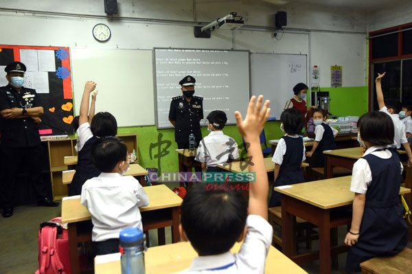 当马永来询问学生是否有兴趣当警察时，不少学生都举手回应，右为郑靖桦校长。