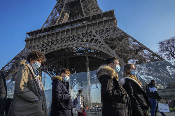 巴黎Omicron病例增加，戴口罩的民众走过艾菲尔铁塔。（美联社）
