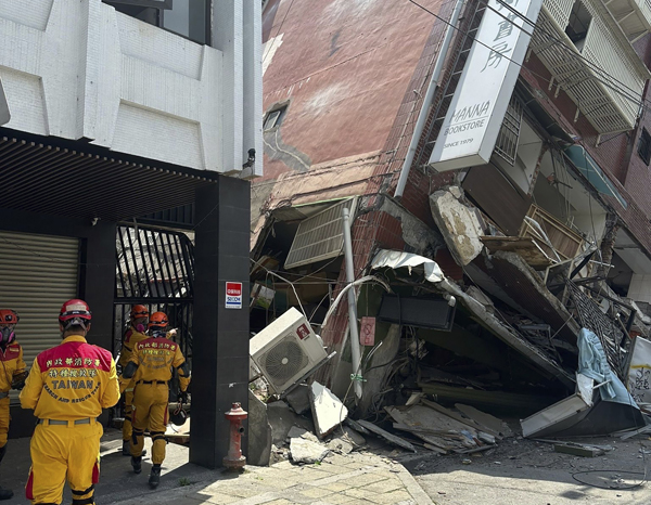 In this photo released by the National Fire Agency, members of a search and rescue team prepare outside a leaning building in the aftermath of an earthquake in Hualien, eastern Taiwan on Wednesday, April 3, 2024. Taiwan\'s strongest earthquake in a quarter century rocked the island during the morning rush Wednesday, damaging buildings and creating a tsunami that washed ashore on southern Japanese islands. (National Fire Agency via AP)