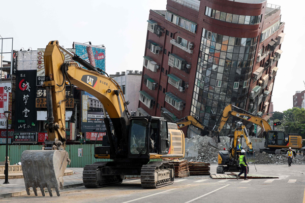 This photo taken by Taiwan\'s Central News Agency (CNA) on April 4, 2024 shows bulldozers being used to remove debris near a damaged building in Hualien, after a major earthquake hit Taiwan\'s east. Taiwan rescuers worked on April 4 to reach scores of people trapped in highway tunnels as engineers began a massive clear-up operation a day after the island\'s biggest earthquake in a quarter of a century. (Photo by CNA / AFP) / Taiwan OUT - China OUT - Macau OUT / Hong Kong OUT RESTRICTED TO EDITORIAL USE