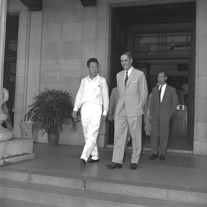 1959年6月5日，李光耀（左）宣誓为首任总理的仪式结束后，与时任新加坡殖民地总督顾德（中）步出政府大厦。