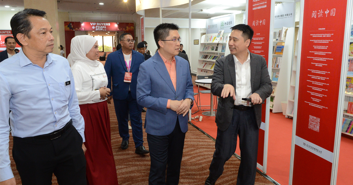 黄家和（右2）在再那阿巴斯（左起）和阿迪峇的陪同下逛书展，看看来自中国的书籍。